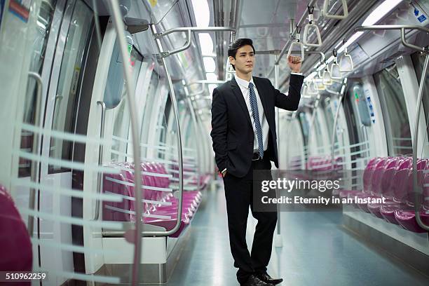 businessman standing in a train car. - handle stock-fotos und bilder