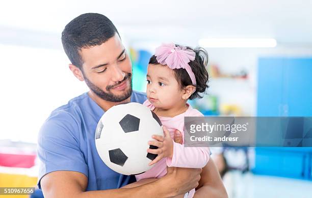 infermiera che gioca a calcio con una bambina - baby football foto e immagini stock