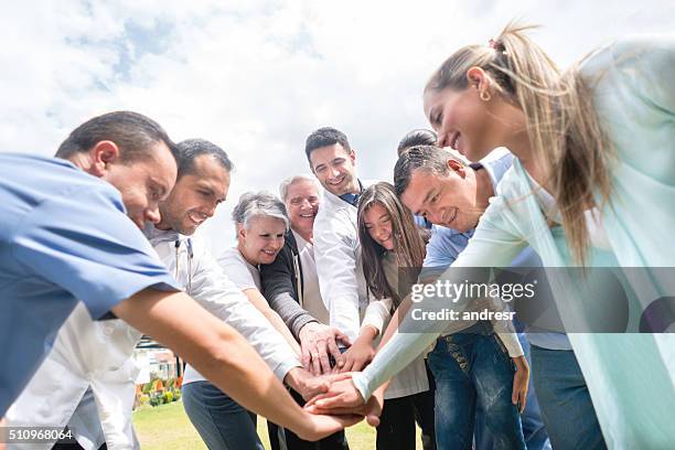 personale medico e pazienti con le mani insieme - group of patients foto e immagini stock