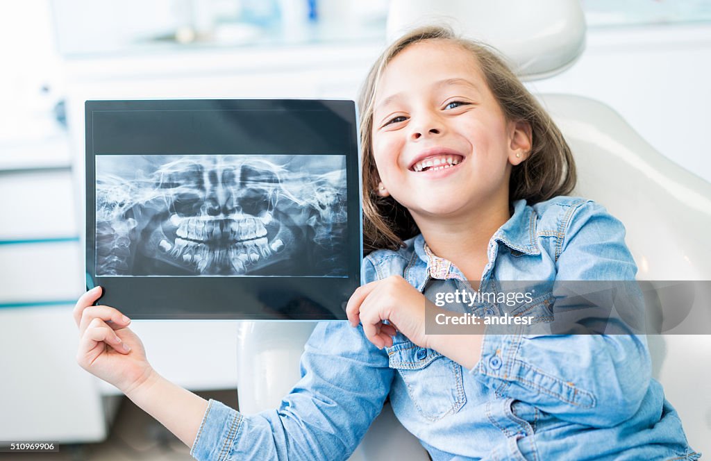Girl at the dentist holding an x-ray