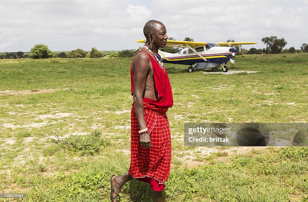 Maasai and safari palne on African savannah