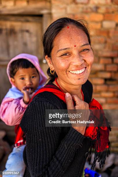 young nepali woman carrying her baby - nepali mother stock pictures, royalty-free photos & images
