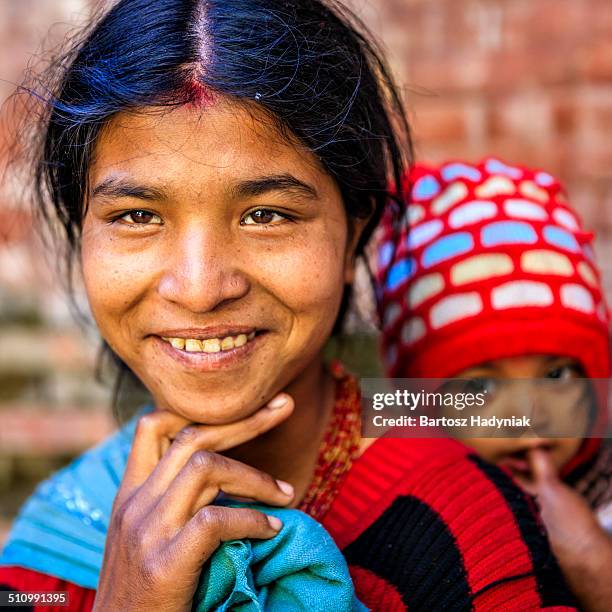 young nepali woman carrying her baby - nepali mother stock pictures, royalty-free photos & images