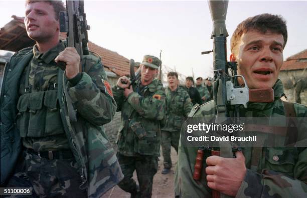 Soldier In The Kosovo Liberation Army Sings As He Marches With His Column Back Into Svrhe After Returning From The Front Lines Sunday March 14, 1999...