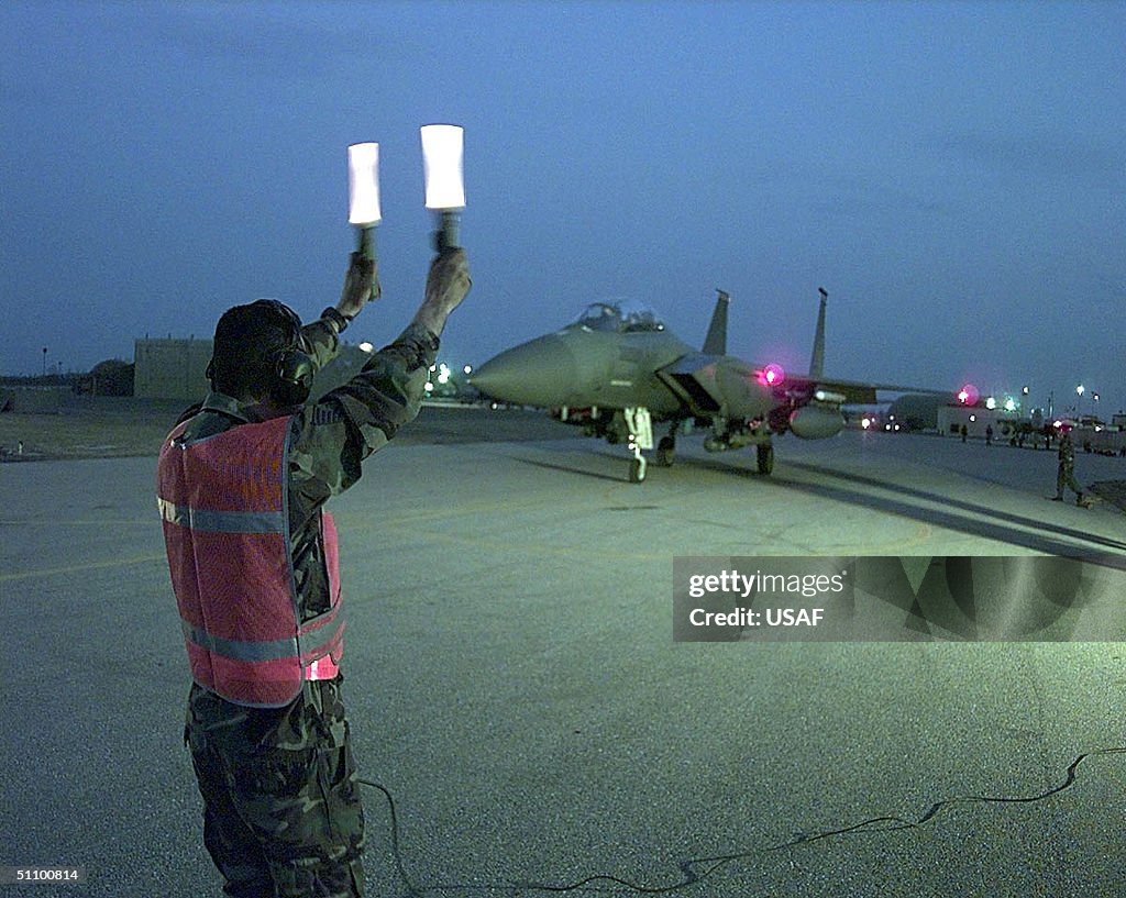 Member Of The 494Th Fighter Squadron Waits For An F 15E Strike Eagle To Taxi Out For Final Checks