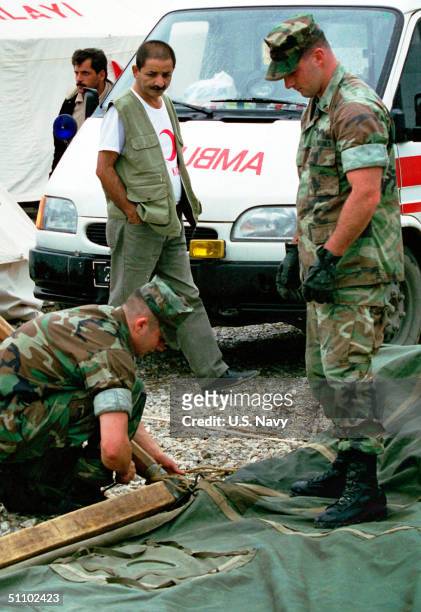 Red Crescent Camp Worker Watches As U.S. Marines From The 26Th Marine Expeditionary Unit Prepare To Put Up The First Of Several Tents At The Relief...
