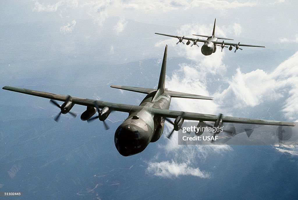 Two C 130E Hercules Aircraft Flying Over Mountainous Terrain