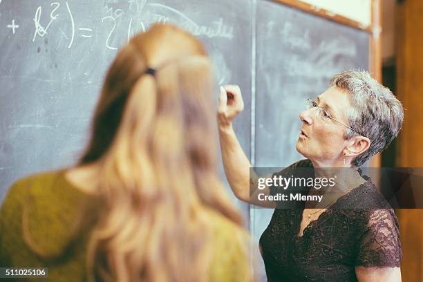 teacher at chalkboard teaching student - two female teachers blackboard stockfoto's en -beelden