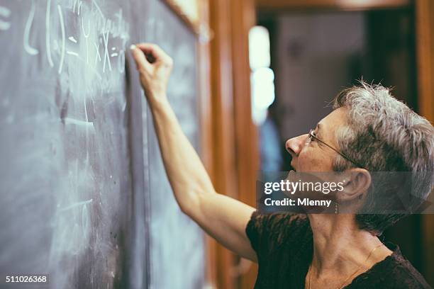 mathemathics professor at chalkboard writing formula - mathematics stock pictures, royalty-free photos & images