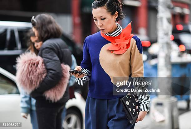 Jeannie Lee is seen outside the DKNY show wearing a striped shirt, 3d graphic sweater and blue pants during New York Fashion Week: Women's...