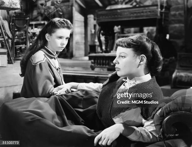 American actresses MArgaret O'Brien and June Allyson as March daughters sitting and lying, respectively, on a chaise lounge in an adaptation of...