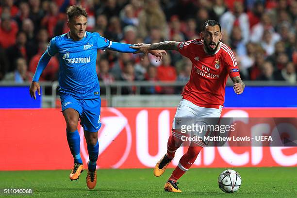 Kostas Mitroglou of Benfica holds off Domenico Criscito of FC Zenit during the first leg of the UEFA Champions League Round of 16 match between SL...