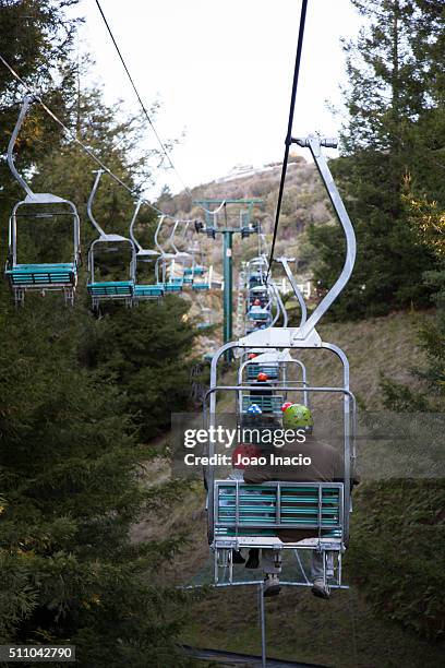back view of child and father on a ski lift - rotorua stock pictures, royalty-free photos & images