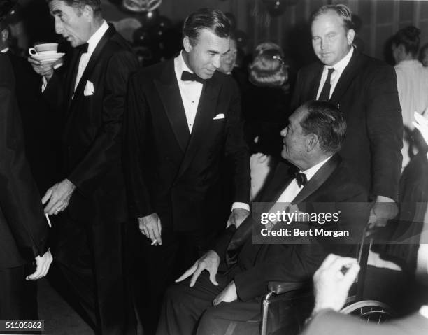 Dominican diplomat and socialite Porfirio Rubirosa speaks with American polo player Stephen Sanford at Coconuts night club, Palm Beach, Florida,...