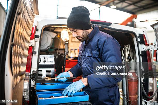 mechanic technician on a garage - bestelwagen stockfoto's en -beelden