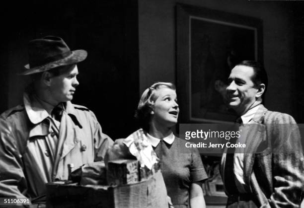 American actors Barry Nelson and Barbara Bel Geddes talk with actor Donald Cook while they hold a box of groceries in a scene from F. Hugh Herbert's...