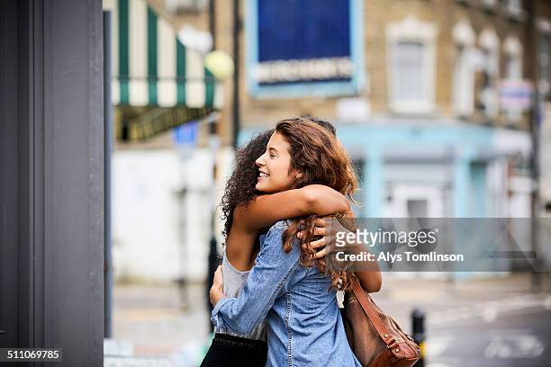 two women hugging outside - embracing stock pictures, royalty-free photos & images