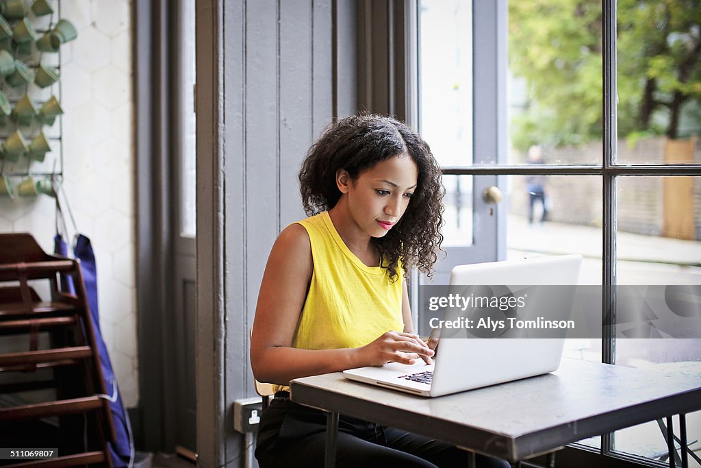 Woman Using a Laptop Computer in a Cafe