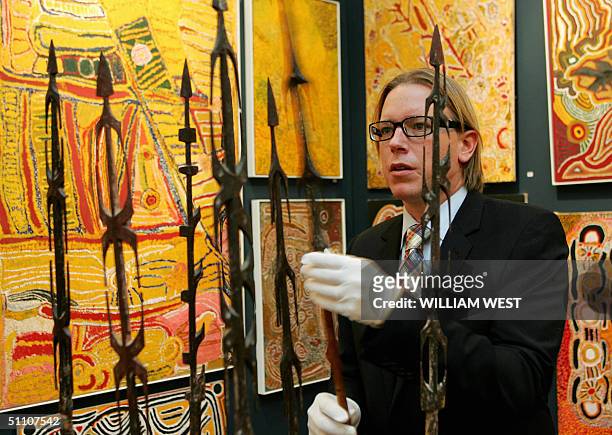 Director of Aboriginal Art at Sotheby's, Tim Klingender inspects a collection of eight ceremonial spearheads which are expected to sold for around...