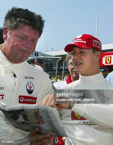 German Ferrari driver Michael Schumacher talks to RTL comentator Heiko Wasser in the pits of the Hockenheim racetrack during the first free practice...