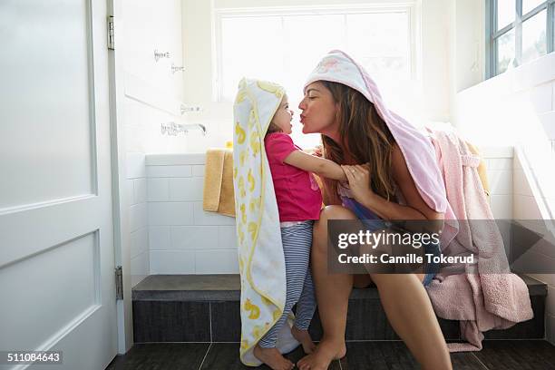 mother trying to kiss little girl - mother daughter towel fotografías e imágenes de stock