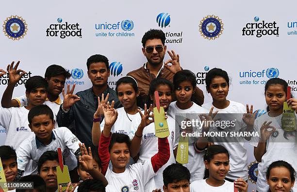 Indian cricketers Yuvraj Singh and Pawan Negi pose with children during an event to launch an initiative advocating for disadvantaged children with a...