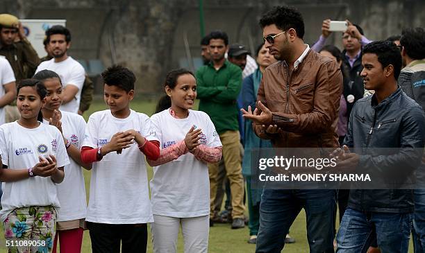 Indian cricketers Yuvraj Singh and Pawan Negi interact with children during an event to launch an initiative advocating for disadvantaged children...