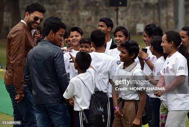 Indian cricketers Yuvraj Singh and Pawan Negi interact with children at an event to launch an initiative advocating for disadvantaged children with a...