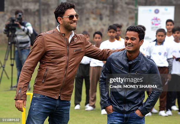 Indian cricketers Yuvraj Singh and Pawan Negi share a light moment during an event to launch an initiative advocating for disadvantaged children with...