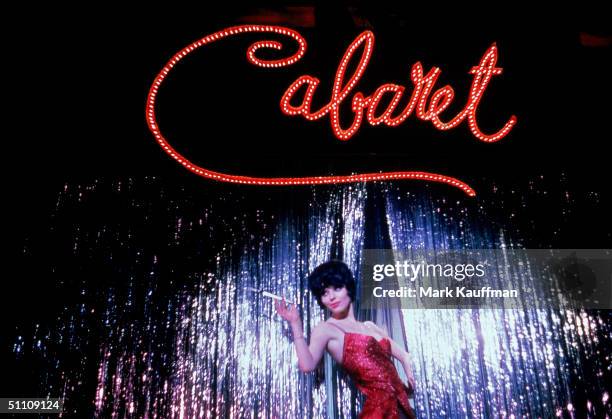 British actress Jill Haworth, playing Sally Bowles, stands under a giant sign in scene from Broadway musical 'Cabaret,' performed at the Broadhurst...