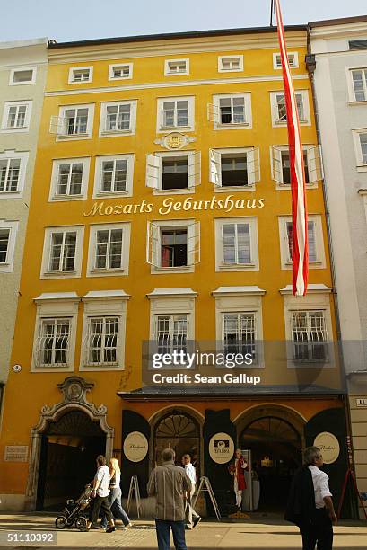 People walk by the birth house of Austrian composer Wolfgang Amadeus Mozart before opening night of the 2004 Salzburg Music Festival on July 23, 2004...