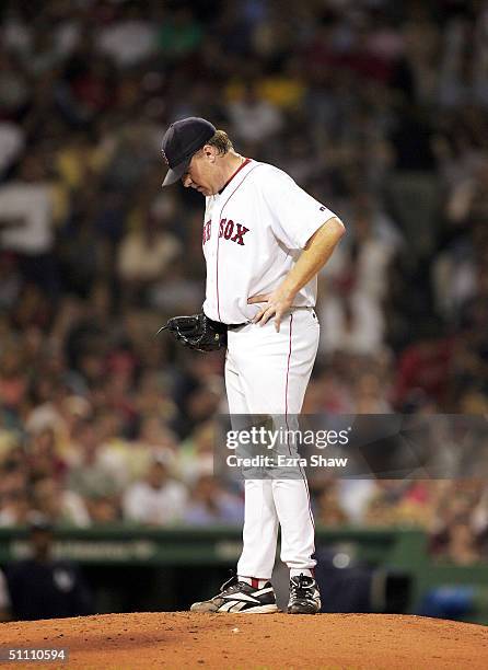 Curt Schilling of the Boston Red Sox looks down after giving up a double to Kenny Lofton of the New York Yankees that scored Hideki Matsui for the...