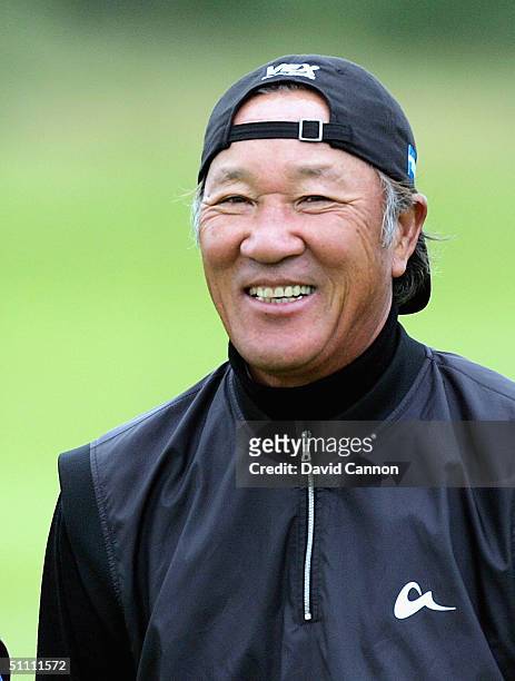 Isao AOki of Japan with his hat turned round to avoid it blowing off in the wind during the third round of the Senior British Open on the Dunluce...