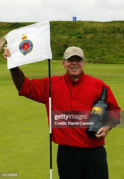 Graham Marsh of Australia stands beside the pin of the 170 yard par 3 hole after sinking two holes in one, July 24, 2004 on the Dunluce Course at...