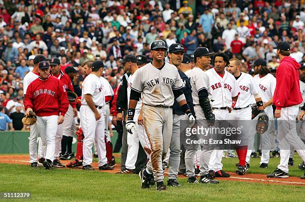 Alex Rodriguez of the New York Yankees walks to first base with hitting coach Don Mattingly after a fight with Jason Varitek of the Boston Red Sox in...