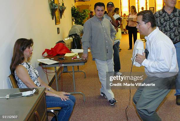 Norma Lunday a Mexican citizen married to an American, has her picture taken by a Mexican Consulate official for a Matricula Consular card at the...