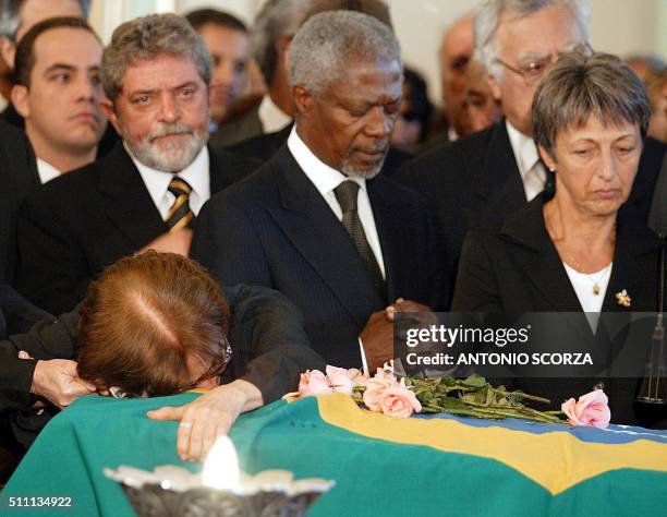 Secretary General Kofi Annan prays while Gilda Vieira de Mello , mother of Brazilian diplomat Sergio Vieira de Mello embraces his coffin, accompanied...