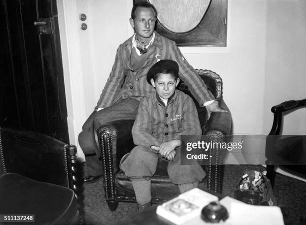 The young Zenek Schwarzbaum and Eric Breuer, survivors of Auschwitz, put on the striped outfit of the death camps and pose in a living room of the...