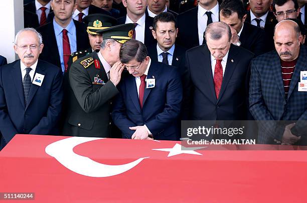 Turkey's Chief of Staff General Hulusi Akar talks with Turkey's Prime Minister Ahmet Davutoglu as they attend with Turkey's President Recep Tayyip...