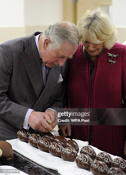 Prince Charles, Prince of Wales and Camilla, Duchess of Cornwall try their hands at piping Easter eggs during their visit to the tasting rooms and...