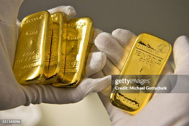 Muenchen, Germany A hand with glove holds a gold bar in the safe of Pro Aurum Gold trading house on February 16, 2016 in Muenchen, Germany.