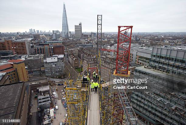 Construction workers and Tate staff stand on a crane shaft in the extension of the Tate Modern on February 17, 2016 in London, England. Construction...