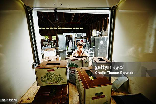 Farmer loading produce boxes into truck
