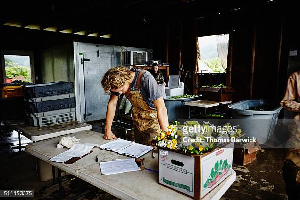 Farmer leaning on table checking delivery log
