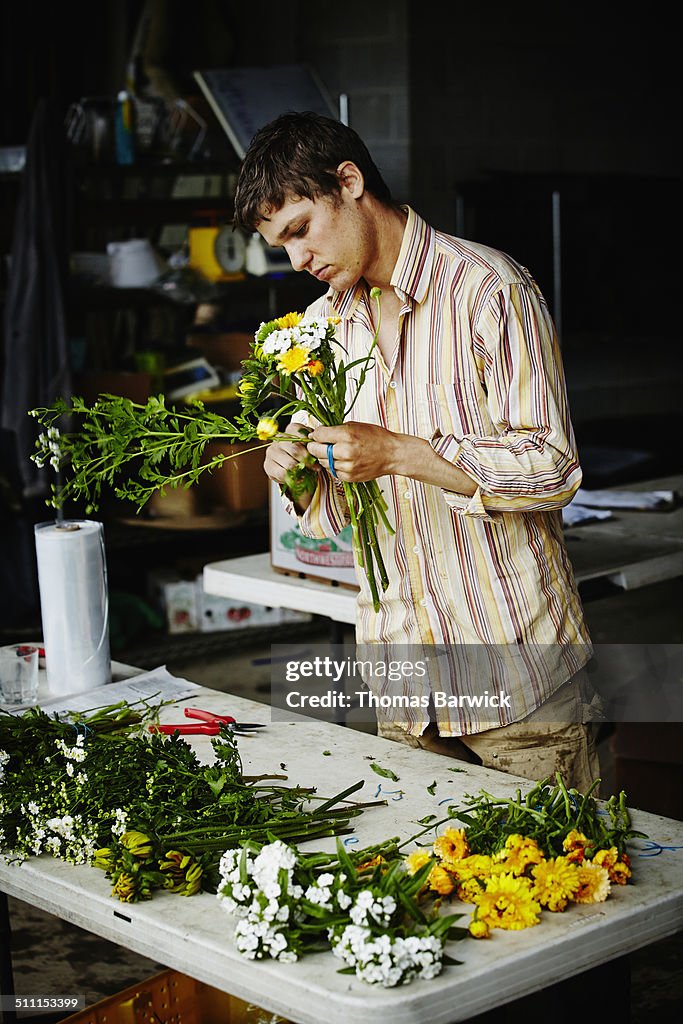 Farmer at table organizing flower bouquets