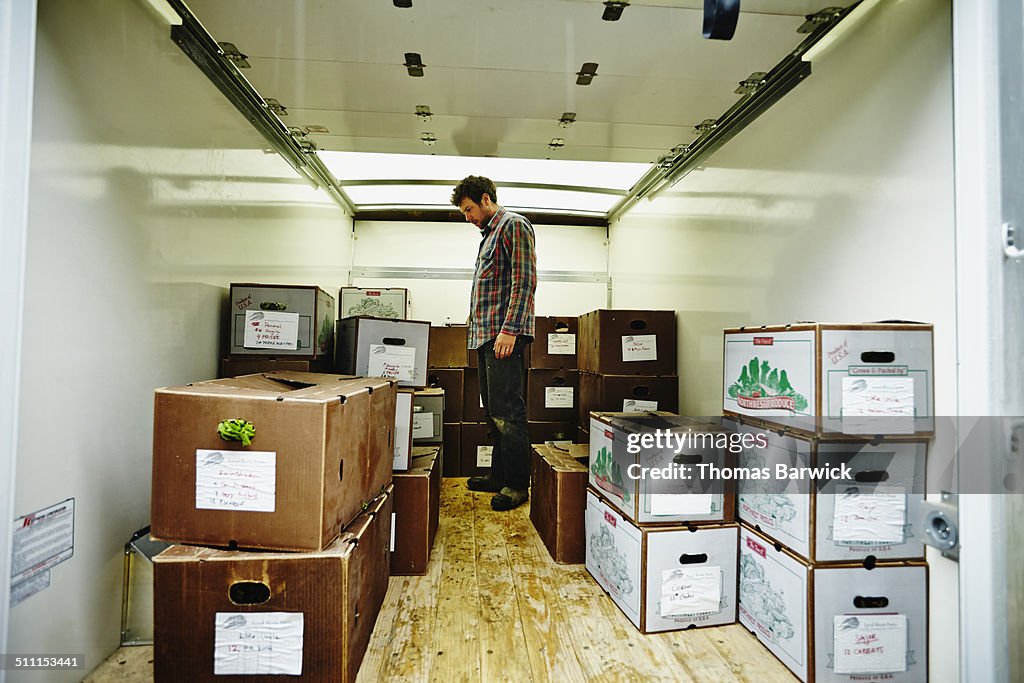 Farmer loading boxes into box truck for delivery