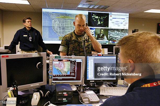 Joint US military and civilian officers monitor TV and computer screens at headquarters for Northcom's Domestic Wing Center May 12, 2004 in Colorado...
