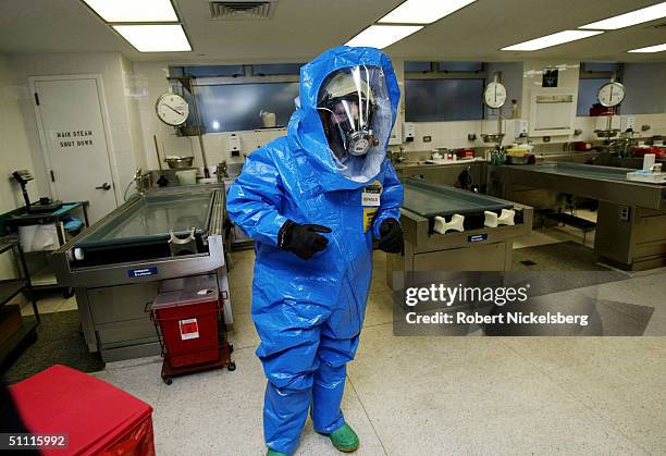 In the main autopsy room for the Office of the Chief Medical Examiner for New York a medical investigator in a Level A Hazmat suite, tests the...
