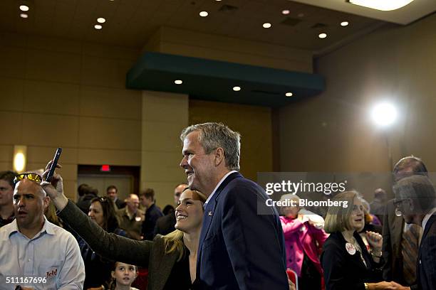 Jeb Bush, former Governor of Florida and 2016 Republican presidential candidate, stands with an attendee for a photograph during a town hall event at...