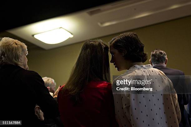 An attendee whispers to her neighbor as Jeb Bush, former Governor of Florida and 2016 Republican presidential candidate, not pictured, speaks during...